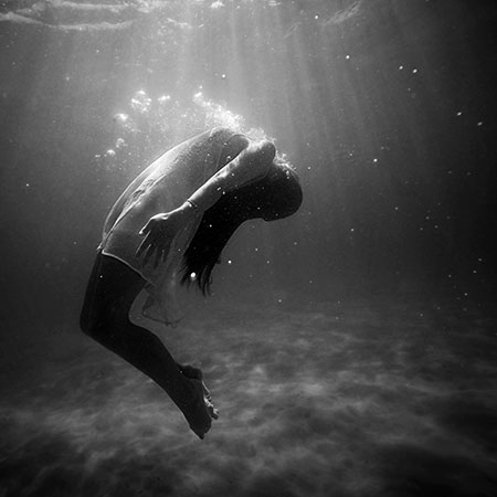A woman struggles to breathe underwater.