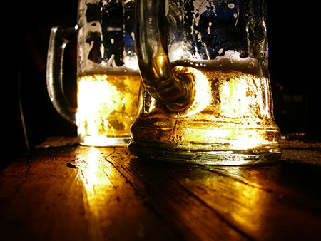 Two mugs of beer on a wooden table
