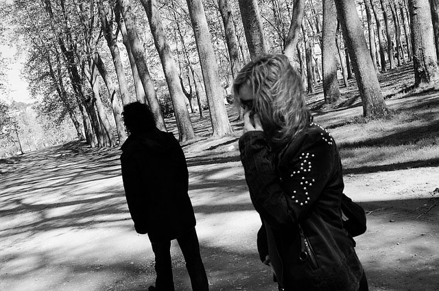 Black and white image of a couple going there separate ways on a trail