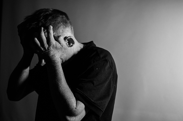 A depressed man holding his head