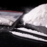 Lines of cocaine, alongside a bag and pile of cocaine.
